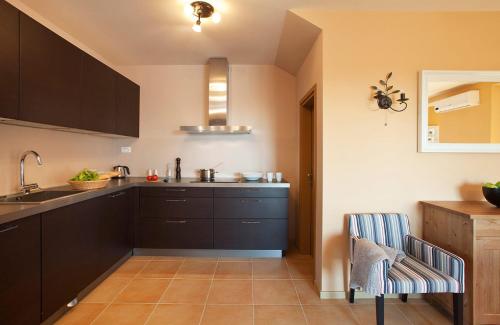 a kitchen with black cabinets and a sink at White Pearl in Čabrunići
