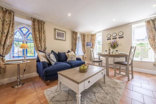 a living room with a blue couch and a table at The Clockhouse in North Lopham