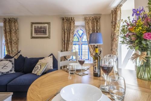 a living room with a table and a blue couch at The Clockhouse in North Lopham