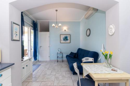 a living room with a blue couch and a table at Apartments Rada i Stanislav in Barbat na Rabu