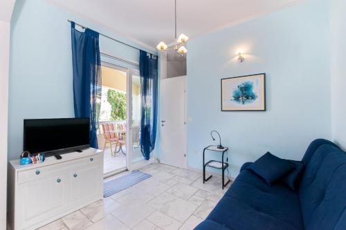 a living room with a blue couch and a tv at Apartments Rada i Stanislav in Barbat na Rabu