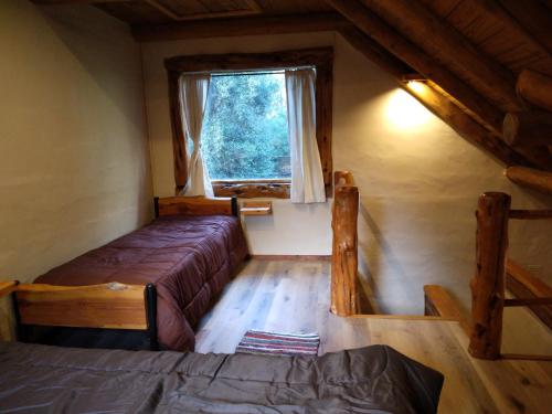 a small room with two beds and a window at El viaje 2 in San Carlos de Bariloche