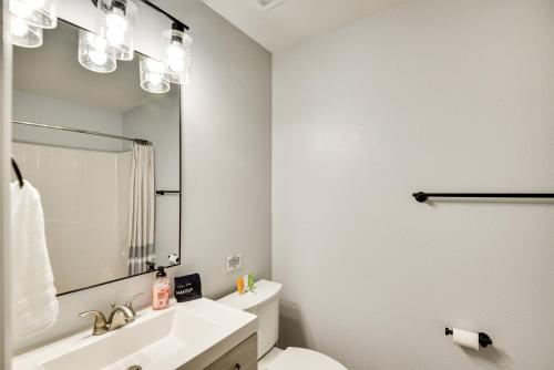 a bathroom with a sink and a toilet and a mirror at Palm Coast Vacation Rental about 8 Mi to Flagler Beach in Flagler Beach