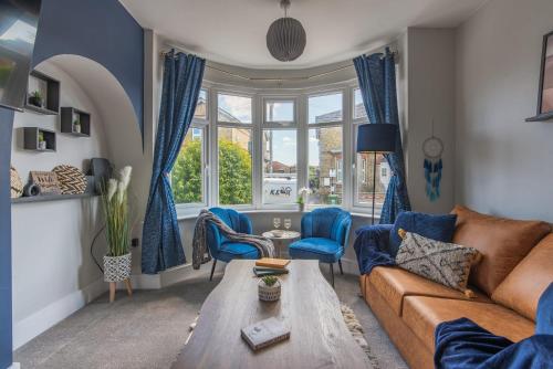 a living room with a brown couch and blue chairs at Spacious 3-Bedroom Stunning Southampton House with Garden & Parking, City Centre Retreat, Great for Families by Blue Puffin Stays in Southampton