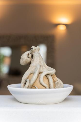 a small figurine of a monkey sitting on a plate at Rhenia Hotel in Tourlos