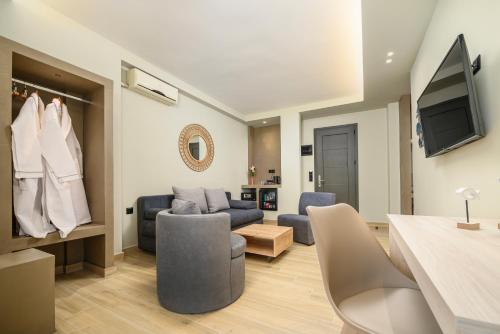 a living room with a couch and a tv at Nicolas Grand Suites, Adults Only in Kardamaina