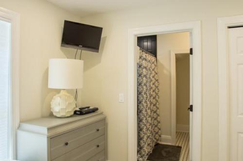 ein Schlafzimmer mit einer Kommode mit einer Lampe und einem TV an der Wand in der Unterkunft Aquarius in St. George Island