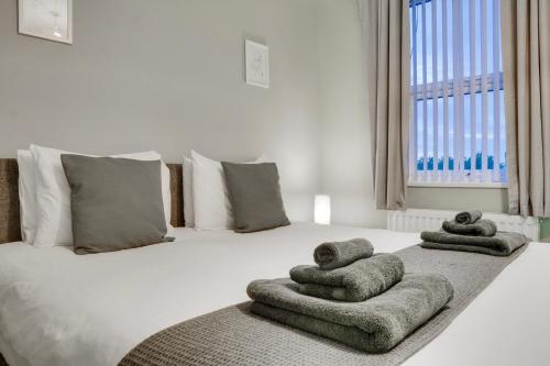 una camera da letto con un letto e asciugamani di Birkenhead - 2 bedroom house a Birkenhead