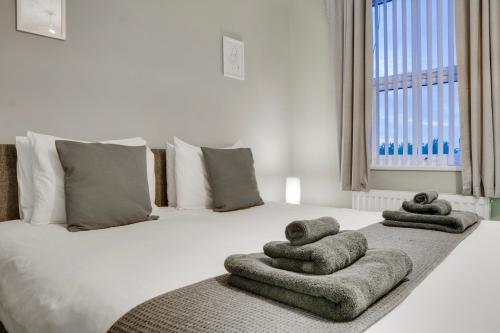 a bedroom with a bed with towels on it at Birkenhead - 2 bedroom house in Birkenhead
