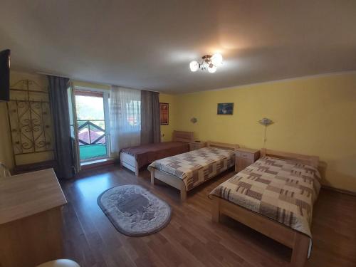 ein Hotelzimmer mit 2 Betten und einem Fenster in der Unterkunft Садиба на Хуторі in Solotschyn