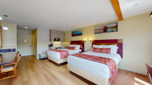 a hotel room with two beds and a table at Surfside On The Lake in Lake George