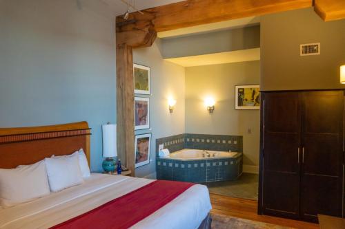 a bedroom with a bed and a tub in a room at Lancaster Arts Hotel in Lancaster