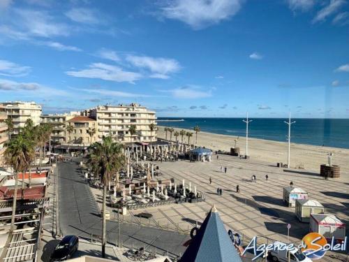 Blick auf einen Strand mit Gebäuden und das Meer in der Unterkunft Le Bel Air in Canet-en-Roussillon