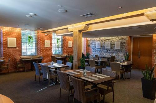 a restaurant with tables and chairs and brick walls at Lancaster Arts Hotel in Lancaster