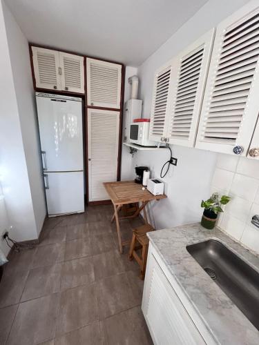 a kitchen with a sink and a refrigerator and a table at Corazón de Vicente López in Vicente López