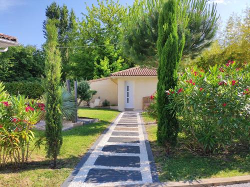 a garden with a pathway leading to a house at Le Clos Fleuri proche de Bordeaux in Saint-Sulpice-et-Cameyrac