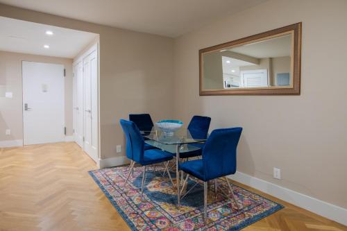 uma sala de jantar com uma mesa de vidro e cadeiras azuis em Cozy Apartment in Upper East Side em Nova York