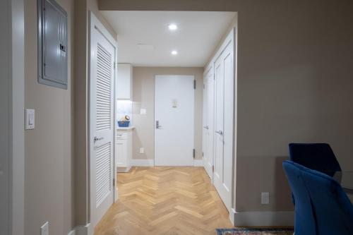 a hallway with white doors and a blue chair at Cozy Apartment in Upper East Side in New York