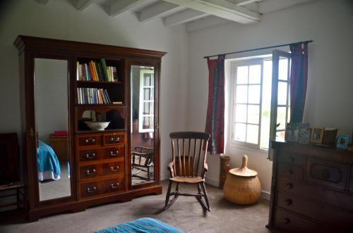 - une chambre avec un miroir, une chaise et une commode dans l'établissement LA GRANGE DU CHAPELAT, à Bourdeilles