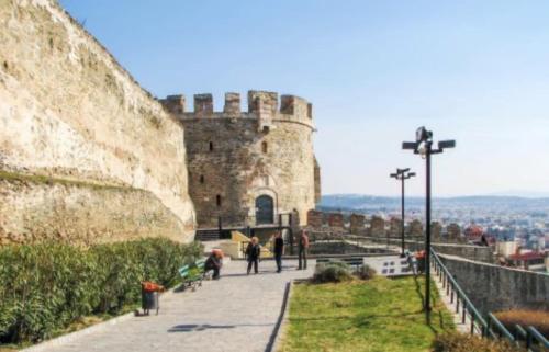 a castle on a hill with people walking on a sidewalk at Dellmar Apartment in Perea