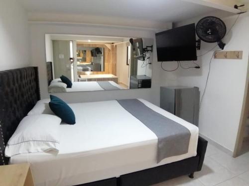 a bedroom with two beds and a flat screen tv at Hotel Urbano 70 in Medellín