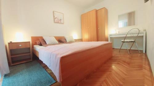 1 dormitorio con 1 cama grande de madera y 1 silla en Apartments Lidija, en Umag