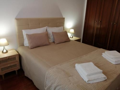 a bedroom with a large bed with towels on it at Vista do Farol in Gafanha da Nazaré