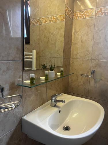 y baño con lavabo blanco y espejo. en Chalet Minut, en Vatra Dornei