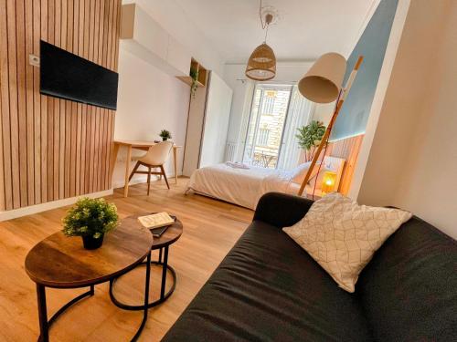 a living room with a couch and a table at Sunshine Getaway - Stylish Studio in the Heart of Nice in Nice