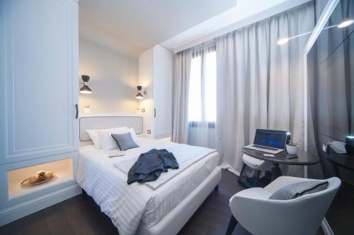 a bedroom with a bed and a desk with a laptop at Hotel Grande Italia in Chioggia