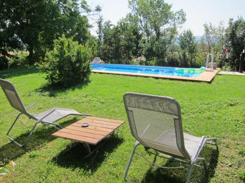 2 sillas y una mesa junto a la piscina en La Fratta Art - House, en Marsciano