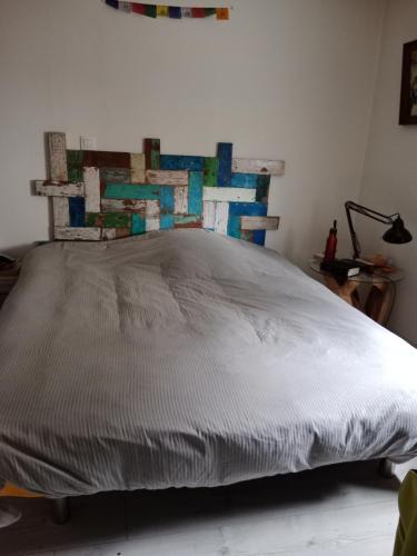 a bedroom with a large bed with a wooden headboard at Maison de charme in Audenge