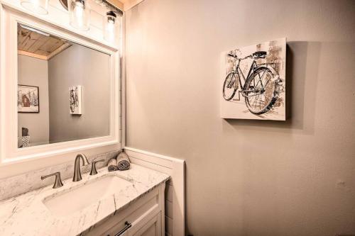 a bathroom with a sink and a picture of a bike on the wall at Modern Mtn Home*Pools*Fire Pit* in Campton