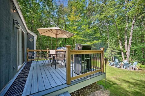 a wooden deck with a table and an umbrella at Modern Mtn Home*Pools*Fire Pit* in Campton