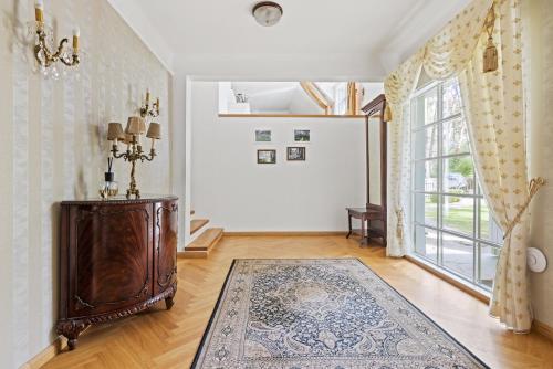 a living room with a large window and a rug at Villa Muusa with a cozy sauna, swimming pool and large beautiful garden in Tallinn