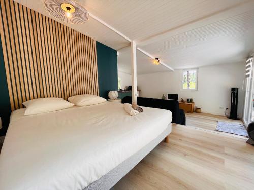 une chambre avec un grand lit blanc dans une pièce dans l'établissement Chez So and Lo, à Garéoult