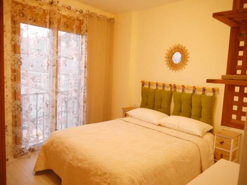 una camera con un letto bianco e una finestra di Apartamento Guadiana Sol a Estepona