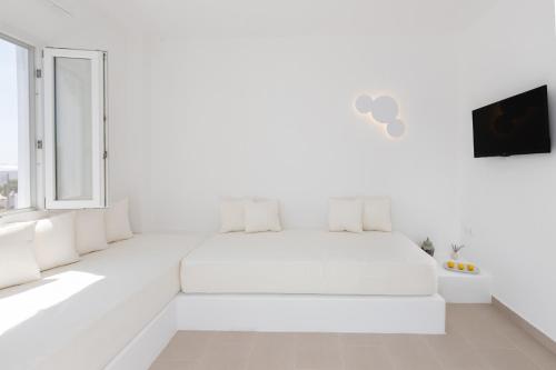 卡馬利的住宿－VOCA HOTEL & SUITES，白色的卧室设有白色的床和窗户。
