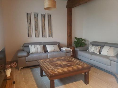 a living room with two couches and a coffee table at Casa Rural Triticum in Navas de Bureba