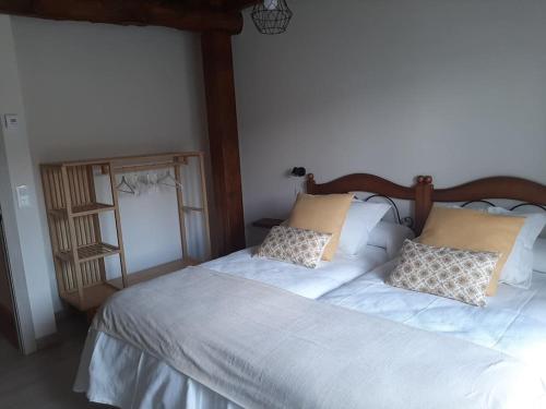 a bedroom with a bed with white sheets and pillows at Casa Rural Triticum in Navas de Bureba