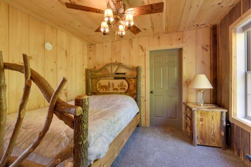een slaapkamer met een bed in een blokhut bij Stunning North Rose Retreat with Fishing Pond! 