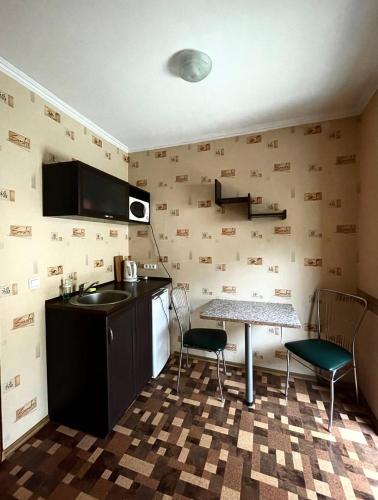 a kitchen with a sink and a table and chairs at Apart-Hotel City Center Contrabas in Lviv