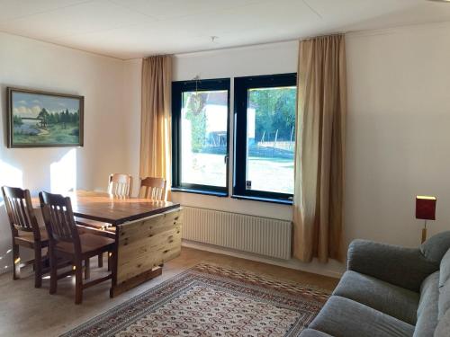 uma sala de estar com uma mesa e cadeiras e uma janela em Björklunden em Gullringen