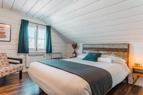 a bedroom with a large bed and a window at Auberge de l'Ouest in Deschambault
