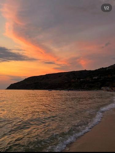 zachód słońca nad plażą z wzgórzem w obiekcie La Bagnarota w mieście Nicotera Marina