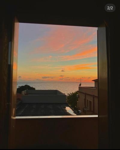 una ventana de un edificio con vistas a la puesta de sol en La Bagnarota, en Nicotera Marina