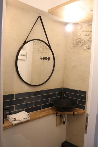 une salle de bain avec un miroir et un lavabo dans l'établissement Esclarmonde 18, à Cascastel-des-Corbières