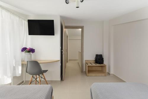 a bedroom with two beds and a desk and a chair at V Luxury Apartments Siviri II in Siviri