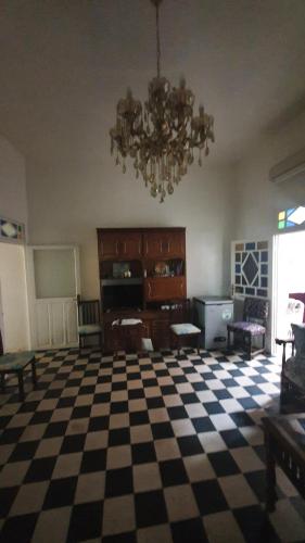 uma sala de estar com piso em xadrez e um lustre em Maison Familiale, vue sur mer à 5 minutes em Larache