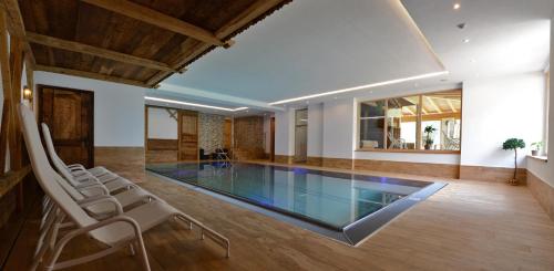 a swimming pool with chairs in a house at Naturhotel Haller in Racines